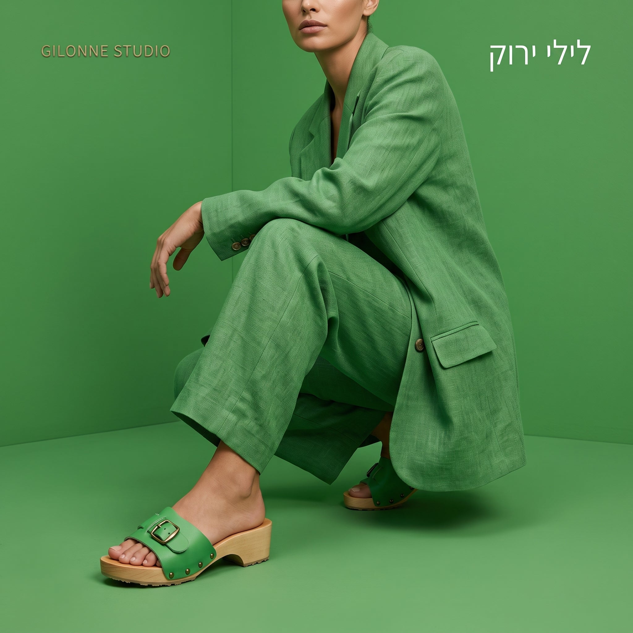 דוגמנית לבושה חליפה בצבע ירוק בחדר כל ירוק נועלת קבקבי-עץ שוודיים נמוכים פתוחים מדגם לילי של ג׳ילון-סטודיו